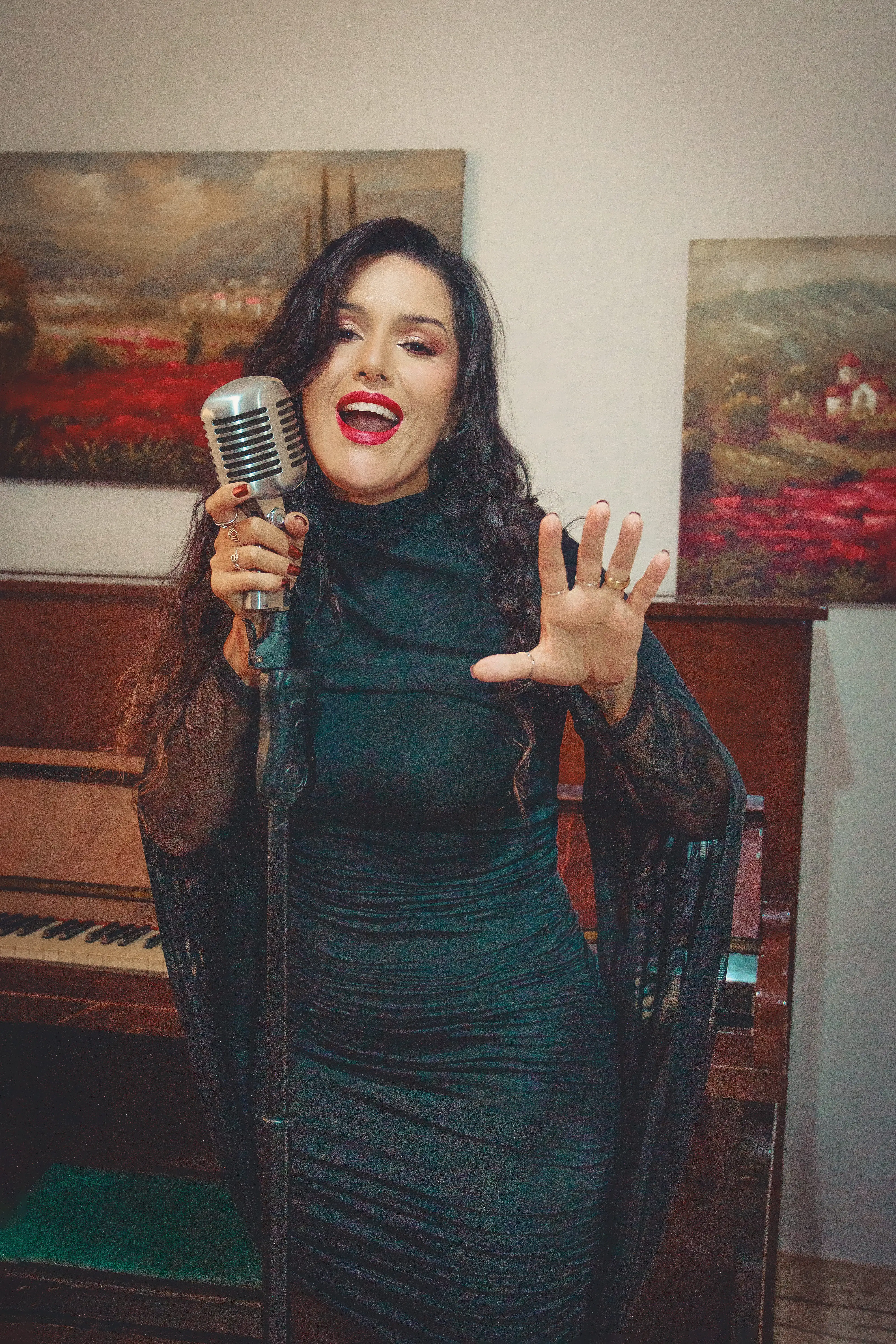 Marina cantando ao lado de um piano